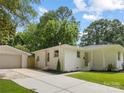 Side view of a beautiful one-story house with white painted brick, a detached garage, and a concrete driveway at 4929 Prentice Pl, Charlotte, NC 28210