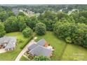 Expansive backyard with brick patio, fire pit and lush green trees surrounding this beautiful brick home at 5410 Berryview Ln, Gastonia, NC 28056