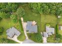 Aerial view shows a brick home with a large backyard featuring a patio and lush greenery at 5410 Berryview Ln, Gastonia, NC 28056