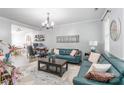 Inviting living room featuring stylish blue leather sofas, a modern chandelier, and neutral decor at 5623 Fetzer Nw Ave, Concord, NC 28027