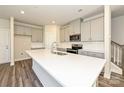 Modern kitchen with gray cabinets, a white countertop island, and stainless steel appliances at 7028 Alva Ter, Charlotte, NC 28216