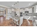 Modern kitchen with stainless steel appliances, granite countertops, a spacious island, and wood flooring at 7046 North Bridge Dr, Huntersville, NC 28078