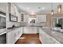 Bright kitchen featuring stainless steel appliances, granite countertops, white cabinets, and a spacious island at 7046 North Bridge Dr, Huntersville, NC 28078