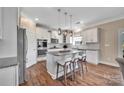 Modern kitchen with stainless steel appliances, granite countertops, a spacious island, and wood flooring at 7046 North Bridge Dr, Huntersville, NC 28078