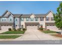 Charming townhouse with a two-car garage, stone accents, manicured lawn, and colorful exterior at 709 Volta Nw Dr, Concord, NC 28027
