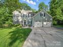 Charming two-story home with a well-manicured lawn, lush trees, and a two-car garage, offering curb appeal at 7344 Maitland Ln, Charlotte, NC 28215