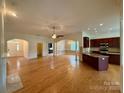 Open-concept living area with hardwood floors seamlessly connecting to kitchen and dining spaces at 8429 Olde Stonegate Ln, Mint Hill, NC 28227