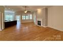 Spacious living room with hardwood floors, a ceiling fan, and a cozy fireplace for relaxing at 8429 Olde Stonegate Ln, Mint Hill, NC 28227