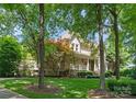 Beautiful two-story home framed by mature trees, features a stone accent and a charming front porch at 8433 Cheverny Dr, Waxhaw, NC 28173