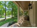 Inviting covered front porch offers a relaxing seating area with stone flooring and views of the lush neighborhood at 8433 Cheverny Dr, Waxhaw, NC 28173