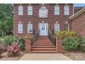 Close-up of the brick home's front entrance with decorative plants and wrought iron railings on the brick staircase at 1185 Willow Creek Dr, Newton, NC 28658