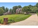 Expansive front lawn with brick mailbox, mature trees, and brick home in the background, offering a serene setting at 1185 Willow Creek Dr, Newton, NC 28658