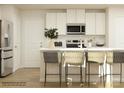 Bright kitchen featuring stainless steel appliances, white cabinets, a modern countertop, and bar stool seating at 130 Oconee Trl, Statesville, NC 28625