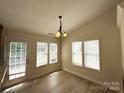 Bright dining area with large windows, hardwood floors, and stylish chandelier at 1423 Napa Nw St, Concord, NC 28027