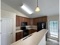 Functional kitchen featuring dark appliances and breakfast bar at 1423 Napa Nw St, Concord, NC 28027