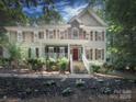 Inviting two-story home with manicured front yard and a welcoming stone staircase to the red front door at 155 Culpeze Rd, Mooresville, NC 28117