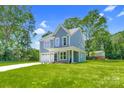 Beautiful home with a well-maintained lawn, showcasing its light blue exterior and inviting curb appeal at 1651 Carolina Cir, Gastonia, NC 28054
