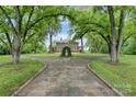 Brick home viewed from a circular drive with mature trees and manicured lawns, offering a grand entrance at 1783 Radio Station Rd, Newton, NC 28658