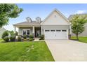 Charming two-story home boasts a manicured lawn, stone accents, and an attached two-car garage at 196 Sutters Mill Dr, Troutman, NC 28166