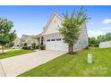 Charming two-story home boasts a manicured lawn, stone accents, and an attached two-car garage at 196 Sutters Mill Dr, Troutman, NC 28166