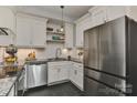 Bright kitchen features stainless steel appliances, white cabinets, black granite countertops, and dark slate flooring at 301 W 10Th St # 404, Charlotte, NC 28202