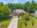 Aerial view of a well-maintained home with lush green lawn and mature trees in a quiet neighborhood at 3633 Longpond Ln, Monroe, NC 28110