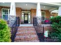 Inviting front porch features brick steps, black railings, and a decorative wreath at 4009 Oxford Mill Rd, Waxhaw, NC 28173