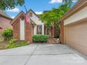 Charming brick home with an American flag, manicured bushes, and attached garage at 5104 Top Seed Ct, Charlotte, NC 28226