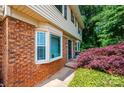 Close-up of home's brick and vinyl siding, featuring a bay window and neatly landscaped bushes at 5516 Northwood Dr, Hickory, NC 28601