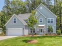 Charming two-story home with a light blue exterior, well-manicured lawn, and an attached two-car garage at 7108 Hambright Rd, Huntersville, NC 28078