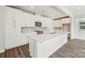 Bright, white eat-in kitchen features stainless appliances, granite countertops, and stylish backsplash at 720 Flare Dr, Tega Cay, SC 29708