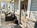 Inviting front porch with seating, a decorative wreath on the door, and stone accents at 9419 Silverdale Ln, Charlotte, NC 28269