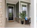 Close-up view of front door and covered entryway with decorated chairs at 1005 Willow Bank Ln, Belmont, NC 28012
