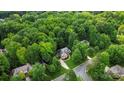 Overhead view of a brick home nestled among tall trees in a quiet suburban neighborhood at 10501 Olde Irongate Ln, Mint Hill, NC 28227