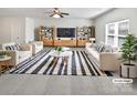 Bright living room featuring stylish furniture, a striped rug, and a ceiling fan at 108 Greenway View Ct, Mount Holly, NC 28120