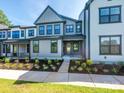 Beautiful new construction townhome featuring a covered entry, stylish gray paint and lush landscaping at 123 Armstrong Rd, Belmont, NC 28012