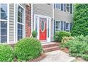 Elegant front entrance with red door, sidelights, brick steps, and manicured shrubbery at 1633 Kiawah Ct, Gastonia, NC 28056