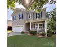 Charming two-story home with inviting front porch, attached garage, and well-maintained landscaping at 1673 Beleek Ridge Ln, Clover, SC 29710
