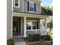 Close up of a welcoming front porch with white railing and manicured landscaping at 1673 Beleek Ridge Ln, Clover, SC 29710