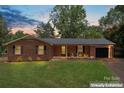 Charming single-story brick home with a well-maintained lawn and an attached one-car garage at sunset at 1713 Andover Nw St, Concord, NC 28027