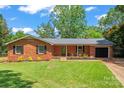 Charming one-story brick home featuring a well-manicured lawn, black shutters, and an attached one-car garage at 1713 Andover Nw St, Concord, NC 28027