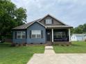 Inviting blue home featuring a cozy covered porch, showcasing curb appeal at 210 Rhyne St, Stanley, NC 28164