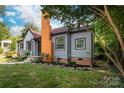 Charming home featuring gray siding, brick foundation, a red roof, and a painted orange brick chimney at 2628 Clydesdale Ter, Charlotte, NC 28208
