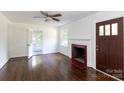 Bright living room featuring hardwood floors, a decorative fireplace, and a ceiling fan at 2628 Clydesdale Ter, Charlotte, NC 28208