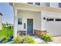 Inviting covered porch with seating, a blue front door, and tasteful landscaping at 322 Olympia Way, York, SC 29745