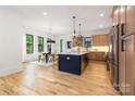 Bright, open kitchen and dining area featuring custom cabinets, stainless appliances, and a large island with seating at 3903 Plainview Rd, Charlotte, NC 28208