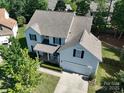 Aerial view of a two-story home with a well-maintained yard, mature trees, and a classic roof design at 4003 Fine Robe Dr, Indian Trail, NC 28079