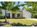Inviting home featuring a covered front porch, lush landscaping, a well manicured lawn and two car garage at 4003 Fine Robe Dr, Indian Trail, NC 28079