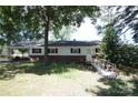 Exterior view of ranch home with ramp and red brick accents surrounded by mature trees in need of TLC at 402 Villa St, Kannapolis, NC 28083