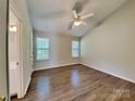 Bright bedroom with laminate floors, ceiling fan, vaulted ceiling, and natural light from two windows at 4328 Frank Vance Rd, Charlotte, NC 28216